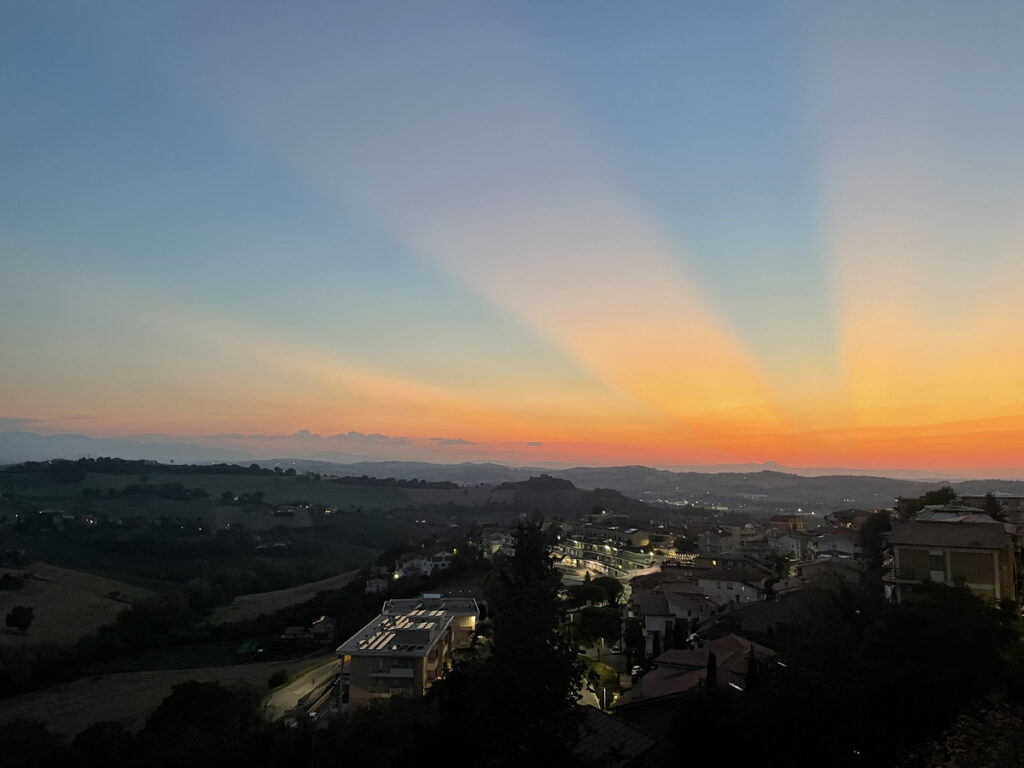 Dramatischer Sonnenuntergang mit Antisolar-Strahlen über den Hügeln der Marken, Fermo, Italien