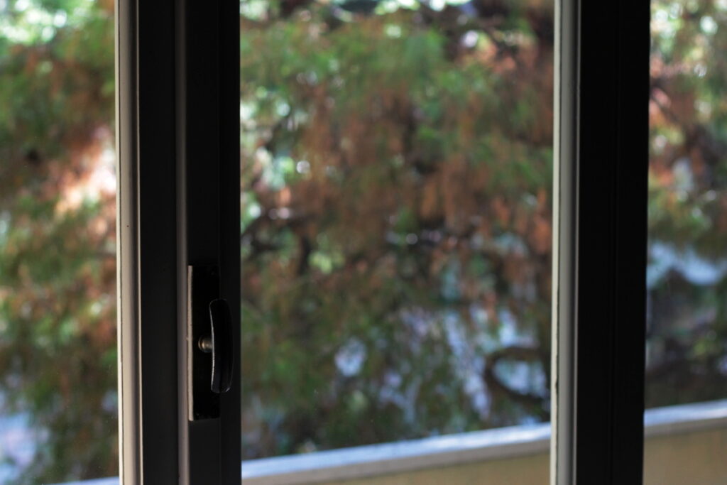 Blick durch ein geöffnetes Fenster ins Grüne – Moment des Nachdenkens über Verantwortung und Umwelt.