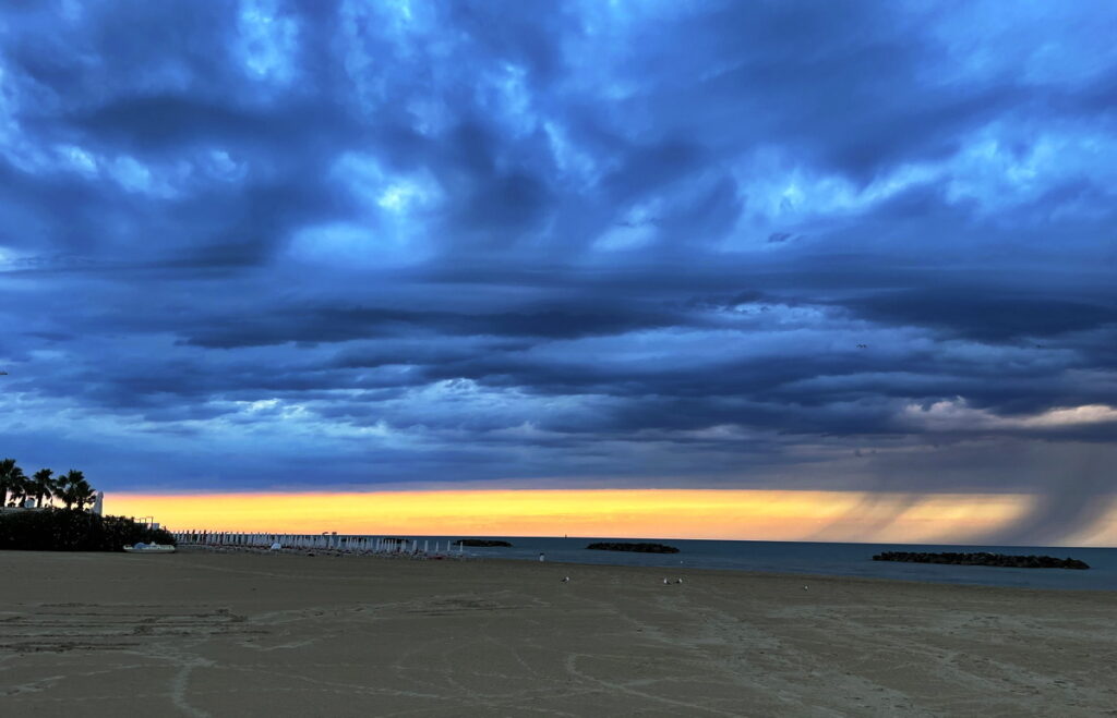 Dramatischer Abendhimmel mit Regenschwaden
über dem plastikfreien Adriastrand bei Fermo, Marken