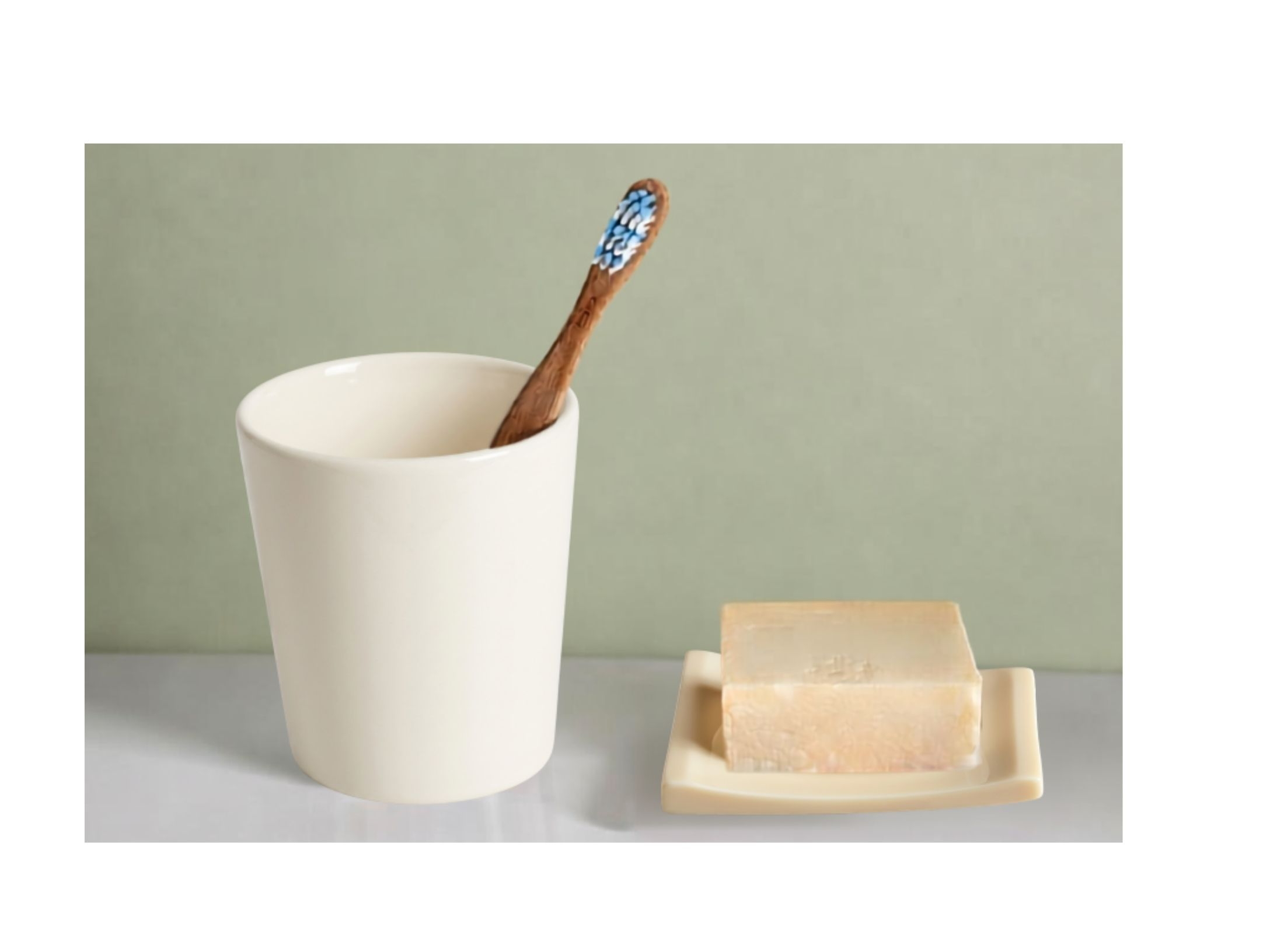 Holzzahnbürste in einem Becher neben einem Stück Naturseife – minimalistisches Badezimmermotiv für plastikfreie Zahnpflege.